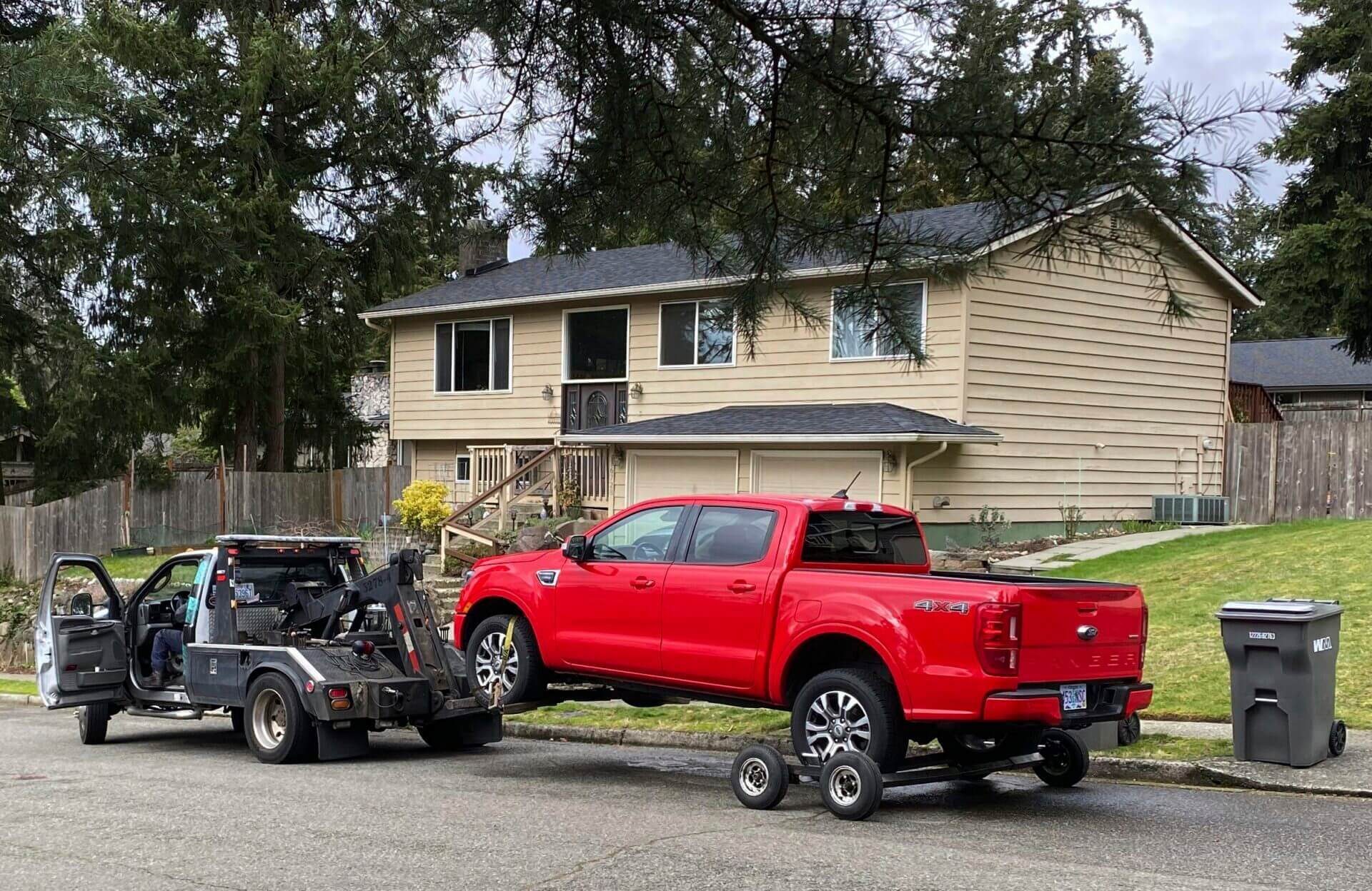 A red truck with Oregon license plates is towed from the scene in Redmond, Wash