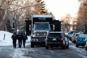 Police investigate the scene where two officers were shot and killed