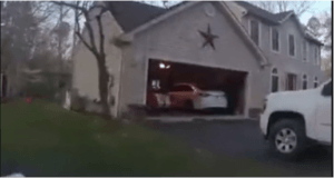 Car in driveway and two cars parked inside garage