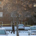 Police investigate the scene where two officers were shot and killed