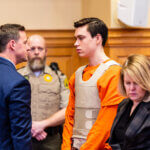 Willard Miller talks with his attorney Nathan Olson while standing beside his other attorney, Christine Branstad