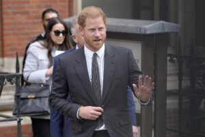 Prince Harry waves to the media.