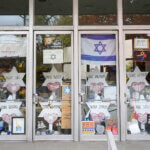 A memorial is placed inside the locked doors of the dormant landmark Tree of Life synagogue