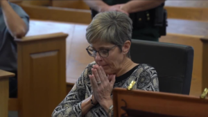 Tracey Nix sits with hands together, as if praying