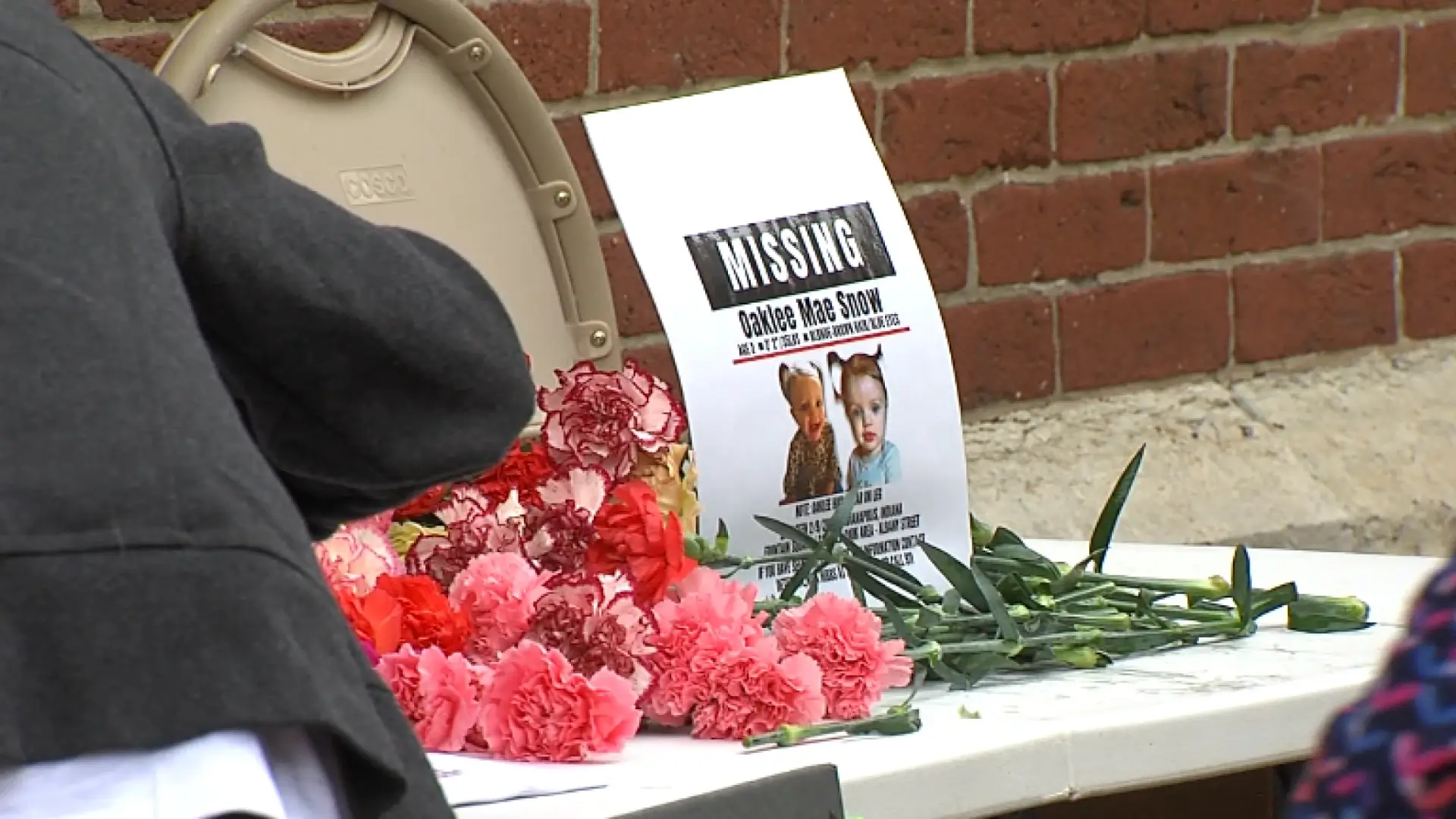 flowers and makeshift memorial with missing child sign