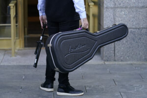 guitar case and feet outside of court