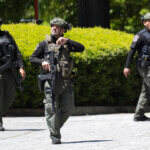 Armed SWAT officers walk towards the camera