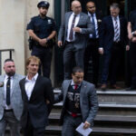 Daniel Penny, center, is walked by New York Police Department detectives