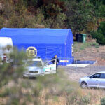 A police tent and vehicles are seen near the Arade dam