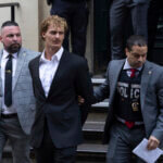 Daniel Penny, center, is walked by New York Police Department detectives