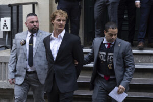 Daniel Penny, center, is walked by New York Police Department detectives