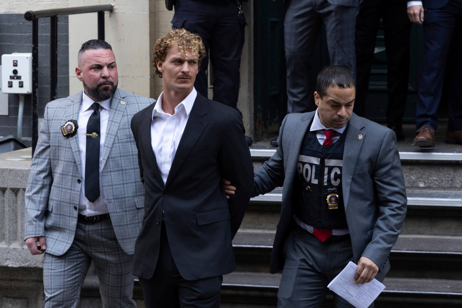 Daniel Penny, center, is walked by New York Police Department detectives