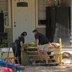 Melissa Salcido, left, and Isaiah Alvarado place flowers on the porch