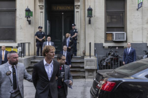 Daniel Penny, center, is walked by New York Police Department detectives