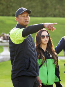 Tiger Woods of the US stands with his partner Erica Herman