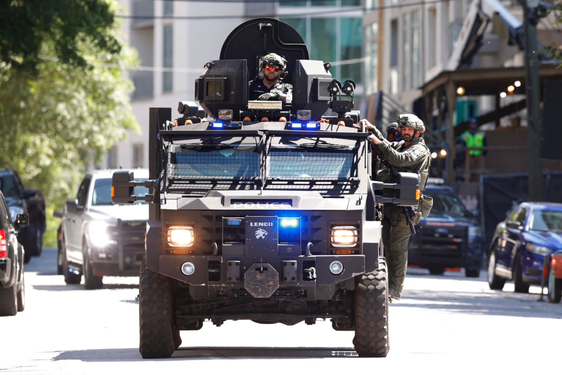 an armored car with officers drives down the street