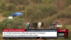 Police vehicles and a blue tent in the distance