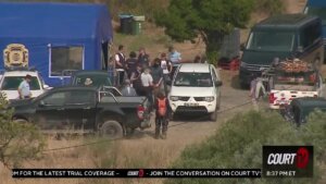 a blue tent, police vehicles and investigators at a reservoir