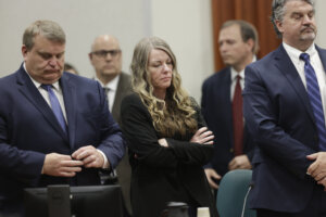 Lori Vallow Daybell stands with arms crossed in court between her attorneys