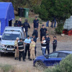 Police officers talk by an operation tent near Barragem do Arade