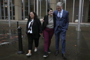 Steve Johnson, right, the brother of Scott Johnson, walks with his wife Rosemarie, left, and daughter Tessa