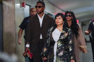 Jonathan Majors, left, and Meagan Good, right, arrive in court
