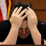 Kyle Laman reacts as surveillance video of the massacre is played in court