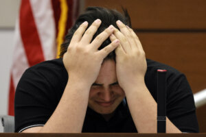Kyle Laman reacts as surveillance video of the massacre is played in court