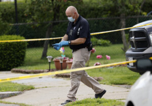 An investigator walks out of a home along Broadway Street