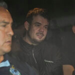 Joran van der Sloot is driven away from prison in a police vehicle.