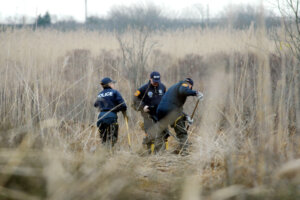 crime scene investigators use metal detectors to search a marsh for the remains of Shannan Gilbert