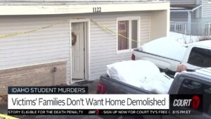 exterior of house with plywood and crime scene tape, snow covered pickup truck parked outside.