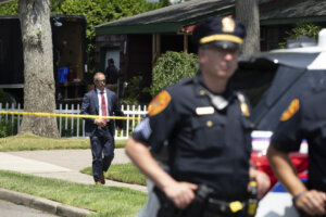 officers stand guard as law enforcement searches the home of Rex Heuermann,