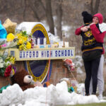 Students hug at a memorial following a shooting at Oxford High School in Oxford, Mich.