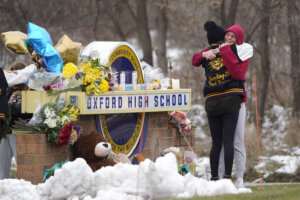 Students hug at a memorial following a shooting at Oxford High School in Oxford, Mich.