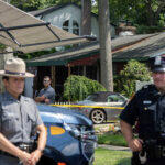 officers stand guard as law enforcement searches the home of Rex Heuermann