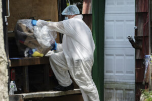 officer places a bag of items into the back of a truck