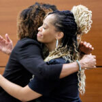 Philana Holmes, right, hugs her attorney.