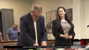 A woman and man stand behind a table