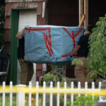 officers carry out a large item as law enforcement searches the home of Rex Heuermann