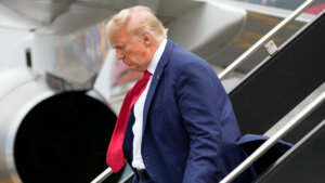 Donald Trump walks down the stairs of a plane