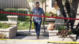 Investigators remove firearms from a house