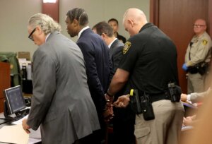 A deputy places handcuffs on Henry Ruggs III in court.