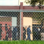 Nine members of Congress and others wait to enter Marjory Stoneman Douglas High School