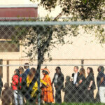 Nine members of Congress and others wait to enter Marjory Stoneman Douglas High School