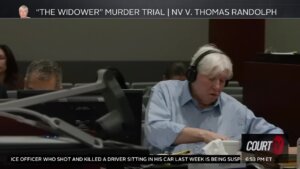 A man sits in court wearing headphones