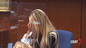 A woman covers her face as she cries on the witness stand