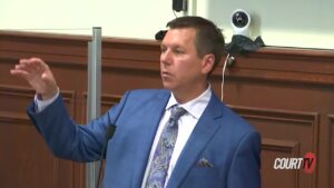 A man in suit gestures as he speaks in court