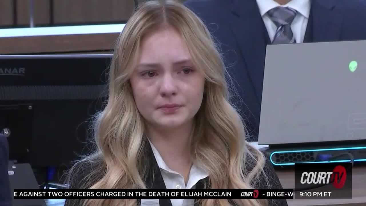 a sad blonde woman sits in court
