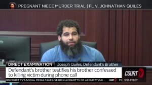 A bearded man wears blue while testifying in court